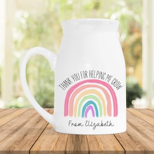 May include: White ceramic mug with a rainbow design and the text "Thank you for helping me grow" and "From Elizabeth".