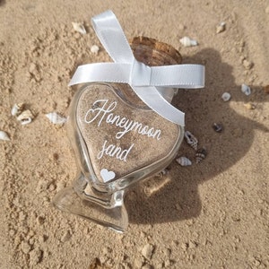 Honeymoon sand. Sweet heart shaped glass bottle jar with a cork and hand finished with ribbon. Personalisation available