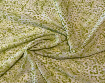 May include: Green and white fabric with a leopard print pattern. The fabric is sheer and has a soft, flowing texture.