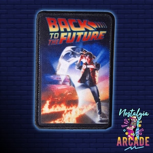 May include: A rectangular patch with the film title "Back to the Future" and a scene of the DeLorean. The patch has a black border and a colour scheme of blue, orange, and yellow. The image includes a person holding a device.