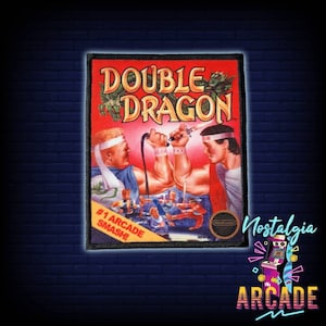 Peut inclure: Un patch brodé représentant le jeu vidéo Double Dragon. Le patch est rouge, blanc et noir avec le texte "Double Dragon" en grandes lettres blanches et le texte "#1 Arcade Smash!" en lettres blanches plus petites. Le patch présente également le logo Nintendo Entertainment System.