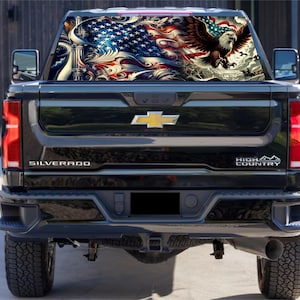 May include: Black pickup truck with a rear window decal featuring an American flag, an eagle, and ornate designs. The truck has "SILVERADO" and "HIGH COUNTRY" badges.