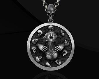 May include: A silver pendant necklace with a round, detailed design. The pendant features a woman's face with a distressed expression, surrounded by skulls.