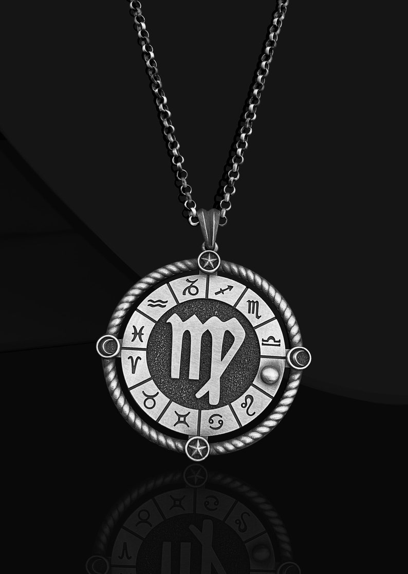 May include: Silver necklace with a round pendant featuring the Virgo zodiac sign surrounded by the other zodiac signs. The pendant has a textured, aged look.
