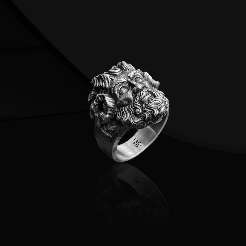 May include: A silver ring with a detailed sculpted face of a man with a beard. The ring is engraved with the word "FREY" and the number "925".