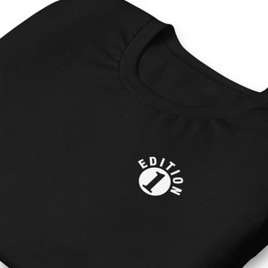 May include: Black t-shirt with a white circle logo that says "Edition 1" in a white font.