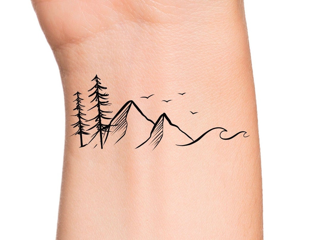 Minimalist mountain tattoo on the tricep.