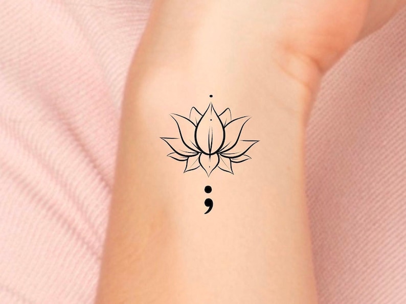 K&ouml;nnte beinhalten: Eine schwarze Linienzeichnung einer Lotusblume mit einem Semikolon darunter.