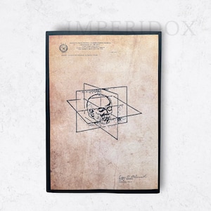 Peut inclure: Une illustration en noir et blanc d'une tête à l'intérieur d'un cube. L'image est sur un fond beige avec du texte en haut et en bas. Le texte en bas indique "Loyd M. MacMillan, Daté à Washington, le 19 mai 1943."