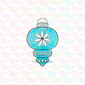 May include: A teal Christmas ornament cookie cutter with a white floral design and small white dots. The ornament has a silver glitter top and a decorative bottom. The cutter is for making holiday cookies.