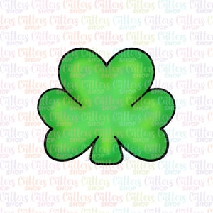 May include: A green shamrock cookie cutter with a black outline. The shamrock has three leaves.