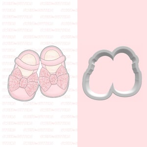 May include: A pair of pink baby shoes with a glitter bow. The shoes are shown next to a cookie cutter in the shape of the shoes.