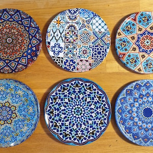 May include: Six decorative ceramic plates with intricate blue, white, and red geometric patterns. The plates feature a variety of designs, including stars, flowers, and geometric shapes.
