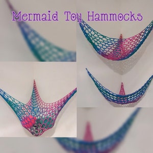 May include: Three crocheted mermaid toy hammocks in pink, blue, and green. The hammocks are hanging from the wall and are designed to hold small toys.