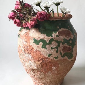 May include: A white ceramic mug with a black handle and the text "But First, Coffee" in a black, bold font. The mug is sitting on a wooden surface. The mug is 4 inches tall.