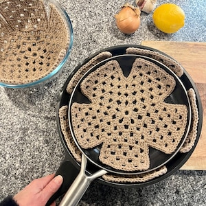 以下が含まれることがあります： クリーム色の斑点のある釉薬が施された、3つのセラミックマグのセット。各マグには、青、緑、黄色の色合いの手描きの花の模様が施されています。マグはシンプルで丸みを帯びた形状で、持ちやすいハンドルが付いています。