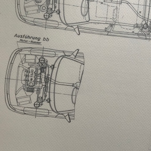 Puede incluir: Un dibujo t&eacute;cnico en blanco y negro de un motor de autom&oacute;vil. El dibujo muestra el motor desde arriba, con el bloque del motor, la culata y otros componentes visibles. El texto "Ausf&uuml;hrung bb" y "Motor-Nummer" es visible en la imagen.