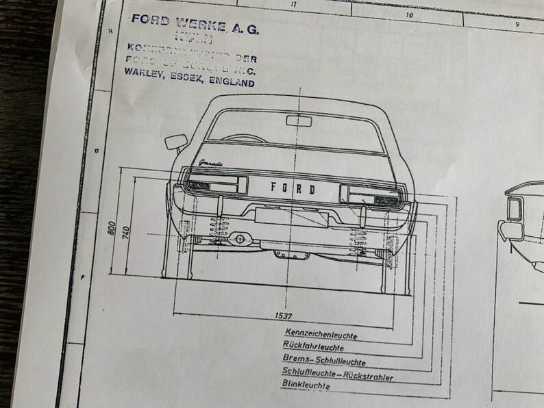 Puede incluir: Un dibujo en blanco y negro de la parte trasera de un coche Ford. El coche est&aacute; etiquetado con "FORD" y tiene una matr&iacute;cula, luces traseras y un parachoques trasero. El dibujo est&aacute; etiquetado con el texto "FORD WERKE, A. G. WARLEY, ESGEX, ENGLAND" e incluye medidas en pulgadas.
