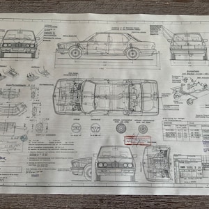 May include: A black and white technical drawing of a BMW 5-series saloon. The drawing shows the car from different angles, including the front, side, and top views. The drawing also includes details of the car's interior and exterior, such as the engine, suspension, and wheels. The drawing is labelled with various technical specifications, including the car's dimensions, weight, and engine size. The drawing is dated 1980.