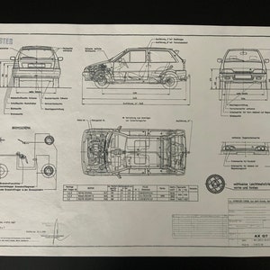 May include: A black and white technical drawing of a car, showing the car from different angles, including the front, back, side, and top views. The drawing includes measurements in inches and centimeters. The car is labeled "AX GT".
