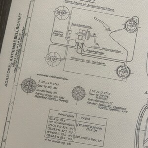 Puede incluir: Un dibujo t&eacute;cnico en blanco y negro de un sistema de frenos de un autom&oacute;vil con un diagrama de las ruedas y los neum&aacute;ticos del autom&oacute;vil. El dibujo incluye texto en alem&aacute;n, incluidas las palabras "Adam Opel Aktiengesellschaft" y "R&uuml;sselsheim am Main".