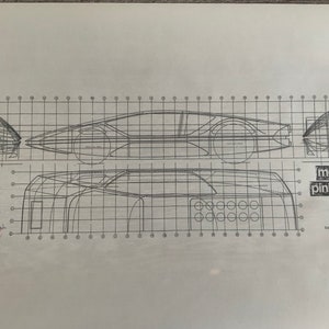 May include: A black and white technical drawing of a car design on a gridded background. The drawing is labeled "modulo pininfarina" and "basic Ferrari 512 S 1969 scale 1:10".