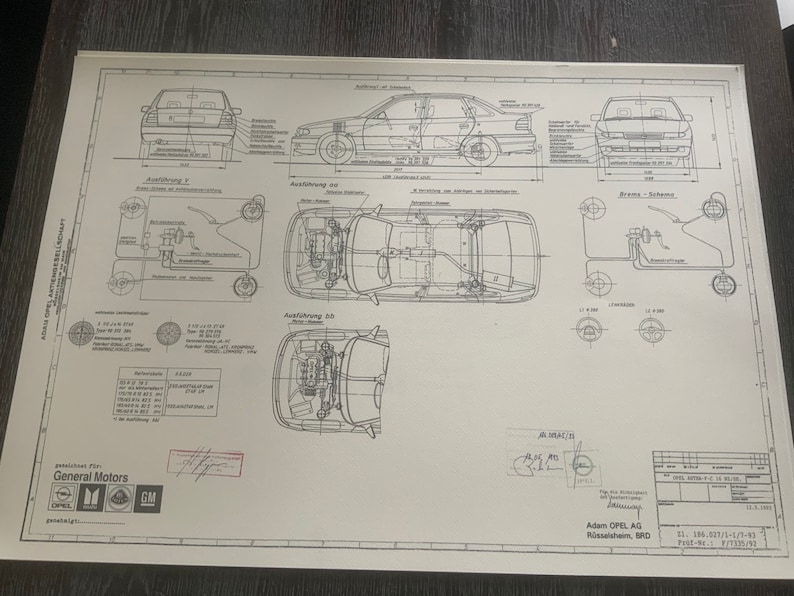 Puede incluir: Un dibujo t&eacute;cnico en blanco y negro de un autom&oacute;vil, que muestra las vistas frontal, lateral y inferior. El dibujo incluye detalles de la suspensi&oacute;n, los frenos y otros componentes del autom&oacute;vil. El dibujo est&aacute; etiquetado como "Adam Opel AG, R&uuml;sselsheim, BRD" y "General Motors".