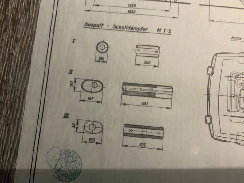 Może przedstawiać: Schemat przedstawiający wymiary r&oacute;żnych konstrukcji tłumik&oacute;w wydechowych. Schemat jest oznaczony jako "Auspuff - Schalld&auml;mpfer M 1:5" i zawiera wymiary w calach.