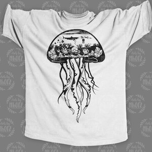 May include: A white t-shirt with a black and white graphic of a jellyfish with an underwater scene inside the bell. The jellyfish has long tentacles and the scene includes a shark, coral, and other sea life.