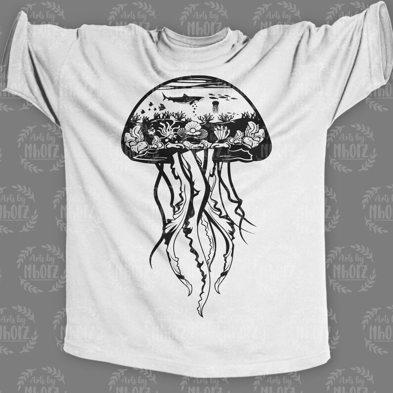 May include: A white t-shirt with a black and white graphic of a jellyfish with an underwater scene inside the bell. The jellyfish has long tentacles and the scene includes a shark, coral, and other sea life.
