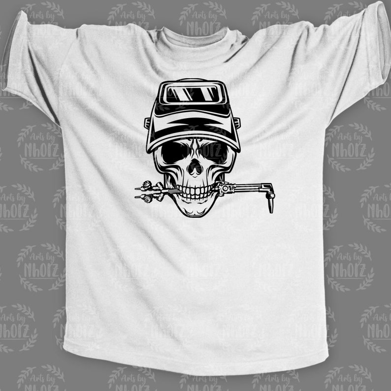 May include: A white t-shirt with a black and white illustration of a skull wearing a welding mask and holding a welding torch in its mouth.