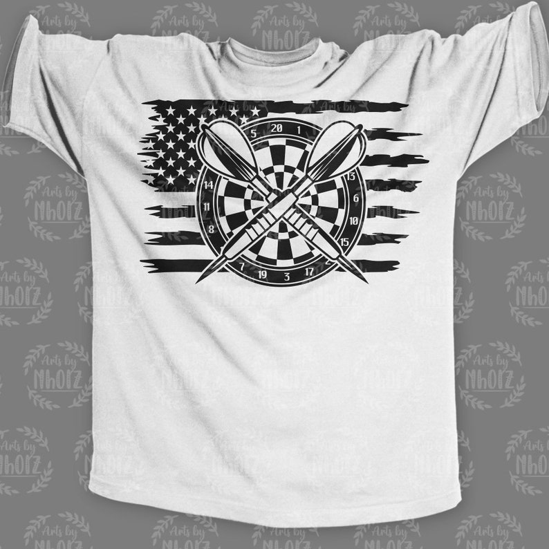 May include: A white t-shirt with a black and white graphic of a dartboard with darts and an American flag in the background.