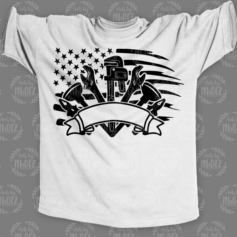 May include: A white t-shirt with a black design of a wrench, pliers, and a pipe wrench in the shape of a heart. The design is superimposed on a stylized American flag.