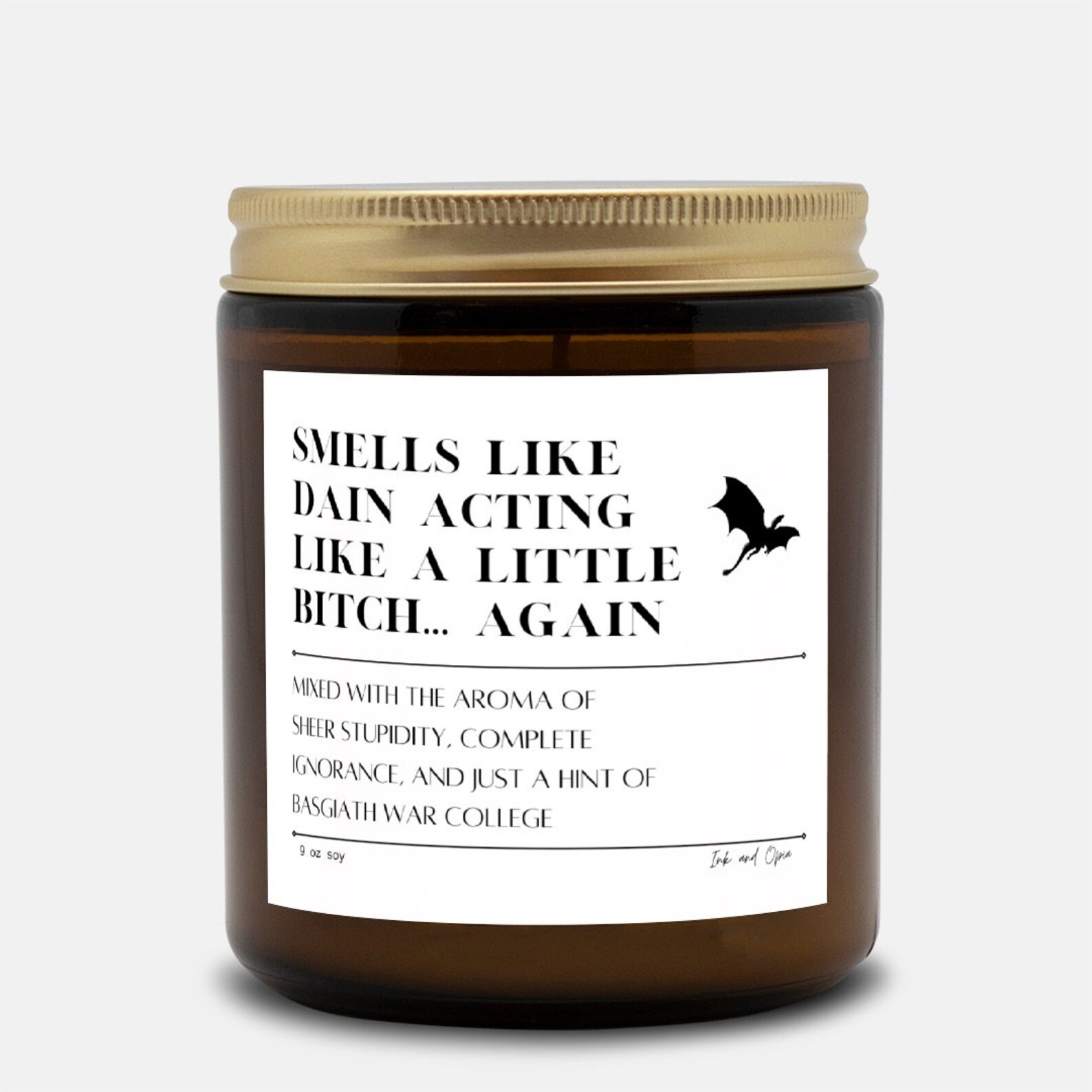 A candle that says "Smells like Dain acting like a little bitch... again" with the sentence "Mixed with the aroma of sheer stupidity, complete ignorance, and just a hint of Basgiath War College" with a small design of a dragon on the top right.