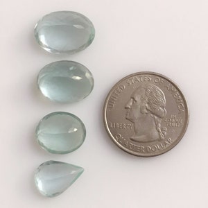 Puede incluir: Cuatro piedras preciosas de aguamarina de forma ovalada de diferentes tama&ntilde;os, siendo la m&aacute;s grande aproximadamente del tama&ntilde;o de una moneda de 25 centavos de d&oacute;lar estadounidense.