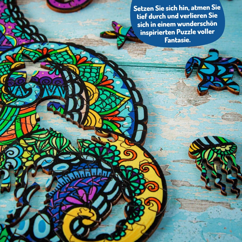 May include: A colorful wooden jigsaw puzzle featuring a seahorse and other sea creatures. The puzzle pieces are intricately designed with mandala-like patterns. The text on the puzzle reads: "Setzen Sie sich hin, atmen Sie tief durch und verlieren Sie sich in einem wundersch&ouml;n inspirierten Puzzle voller Fantasie."