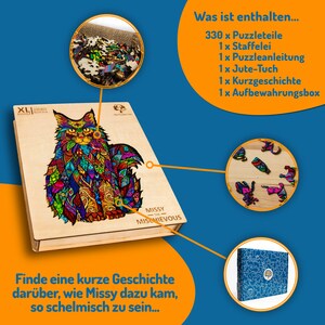 May include: A wooden puzzle box with a colorful cat illustration. The box includes 330 puzzle pieces, an easel, instructions, a jute cloth, a short story, and a storage box. The text on the box reads "XL Puzzle 330 Pieces" and "Missy the Mischievous".