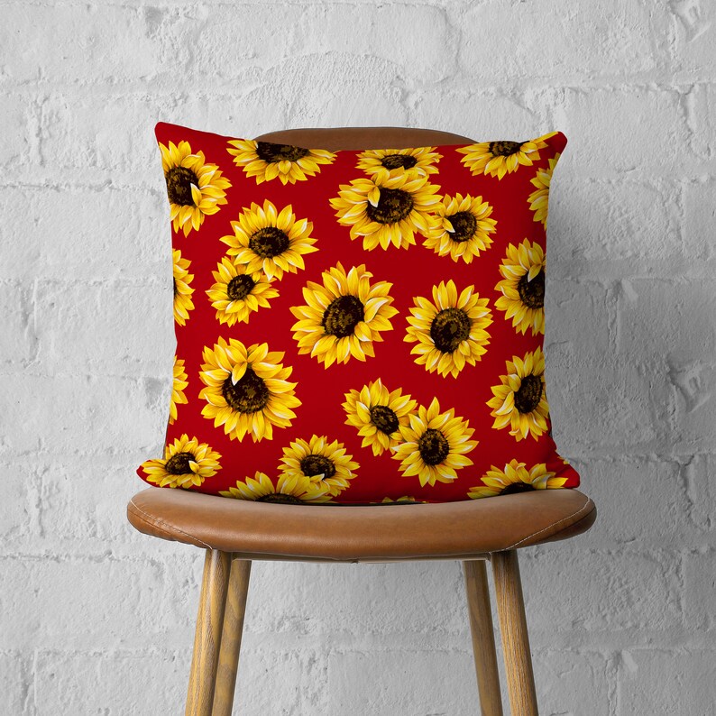 May include: Red throw pillow with a sunflower pattern. The pillow is made of a soft, comfortable fabric and features a zipper closure.