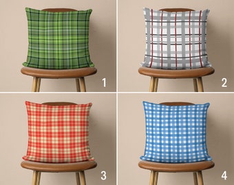 May include: Four brown chairs with different patterned throw pillows. The pillows are green and white plaid, gray and red plaid, red and white plaid, and blue and white gingham.