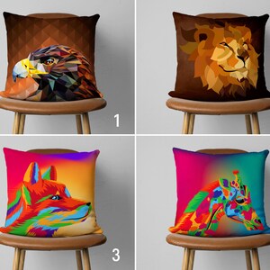 May include: Four colorful throw pillow covers with different animal designs. The pillows feature a geometric eagle, a lion, a fox, and a giraffe. The pillows are all on brown chairs with a white background.