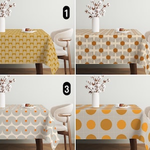 May include: Four patterned tablecloths are shown, each with a different geometric design. The patterns include arched shapes, circles, and a grid of dots. The colour scheme features shades of yellow, orange, brown, and cream. Each tablecloth is draped over a wooden table.