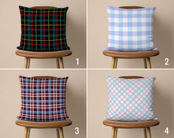 May include: Four different patterned throw pillows on chairs. The pillows are in a variety of colors and patterns, including black and green plaid, light blue and white plaid, purple and white plaid, and light blue and pink plaid.