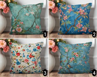 May include: Four decorative throw pillows with floral designs. Pillows feature various color schemes, including teal, blue, and cream, with blossoming branches and flowers. Each pillow has a unique pattern, offering a range of styles for home decor.
