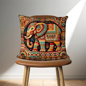 May include: A colorful throw pillow with an intricate design featuring an elephant in the center. The elephant is surrounded by geometric patterns and floral motifs in shades of red, orange, yellow, blue, and green.