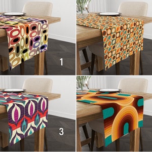 Può includere: Quattro diversi runner da tavolo con motivi geometrici in tonalità di marrone, arancio, giallo, turchese, viola e rosso. I runner sono mostrati su tavoli di legno con sedie.