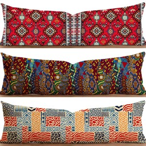 May include: Three decorative lumbar cushions with patterned designs. The top cushion has a red background with geometric patterns. The middle cushion has a colourful, patchwork design. The bottom cushion has a blue, red, and yellow patchwork design.