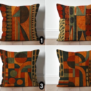 Könnte beinhalten: Vier quadratische Kissen mit abstrakten geometrischen Mustern. Jedes Kissen zeigt ein einzigartiges Design in Orange-, Braun-, Grün- und Schwarztönen. Die Designs umfassen Kreise, Linien und Formen und schaffen einen modernen, künstlerischen Look.