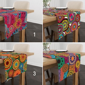 May include: Four different table runners with colorful, geometric patterns. The runners are shown on wooden tables with place settings. The patterns include circles, swirls, and abstract designs in shades of pink, red, orange, yellow, green, blue, and black.