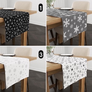 May include: Four table runners with snowflake patterns. The runners are black and white, gray and white, white and gray, and white and black.