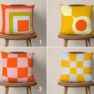 May include: Four different throw pillows with geometric patterns. The pillows are orange, yellow, pink, and white. The pillows are on chairs with brown seats.
